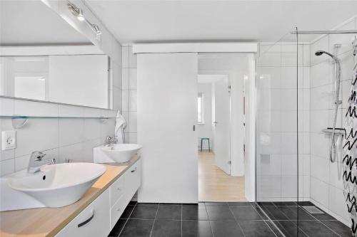 a white bathroom with two sinks and a shower at JB140-Frostrup-Svenstibakkevej-68 in Lild Strand