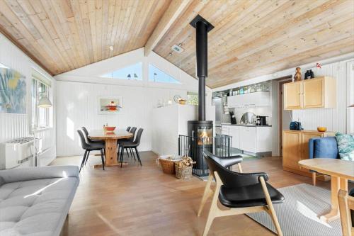 a living room with a fireplace and a table and chairs at JB219-Fjerritslev-Tyttebaerstien-4 in Torup Strand