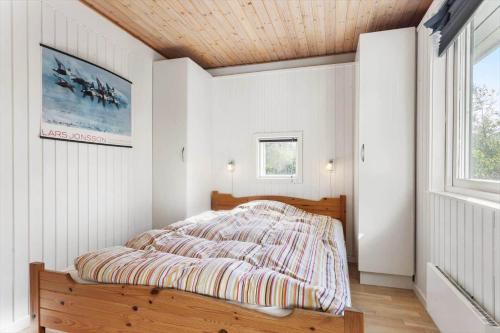 a bedroom with a bed and a window at JB219-Fjerritslev-Tyttebaerstien-4 in Torup Strand