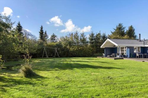 a yard with a house and a playground at JB219-Fjerritslev-Tyttebaerstien-4 in Torup Strand