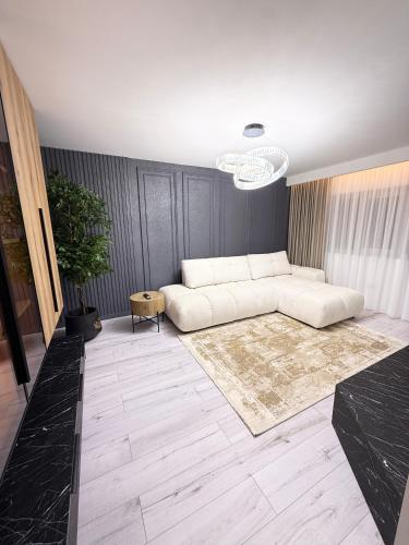 a living room with a white couch and a rug at Apartament Falticeni 3 Camere in Fălticeni
