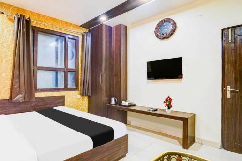 a bedroom with a bed and a desk and a television at Super Collection O Sindhi Camp Formerly Hotel Abhinandan Inn in Jaipur