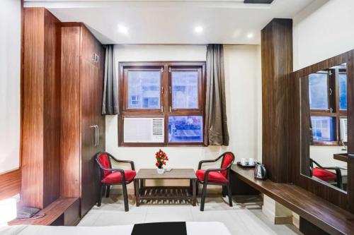a room with a table and two red chairs at Super Collection O Sindhi Camp Formerly Hotel Abhinandan Inn in Jaipur