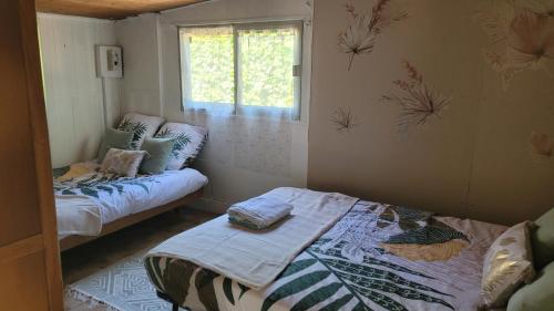 a small room with a bed and a window at maisonnette à la campagne in Saint-Mesmin