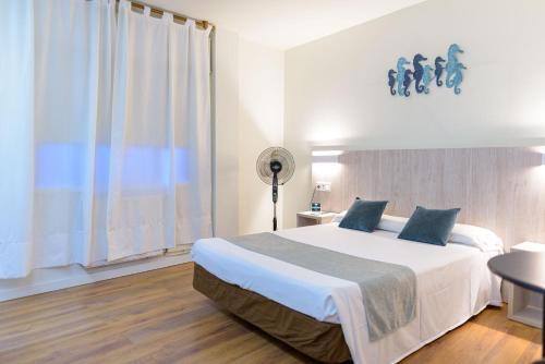 a bedroom with a large white bed and a window at Hotel Alda Ribeira in Ribeira