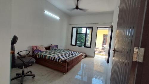 Un dormitorio con una cama y una silla dentro. en Shivang, en Jammu
