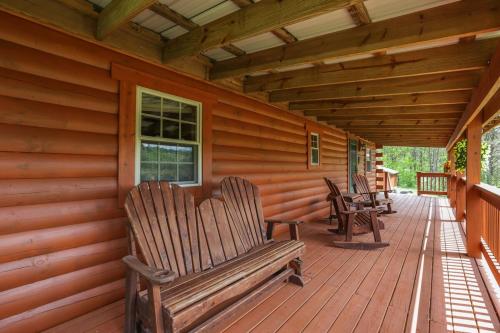 a porch with rocking chairs on a cabin at 10-Acre Cabin, Sauna, Hot Tub, Game Rm, Stargazing Dome, EV, BBQ in Logan