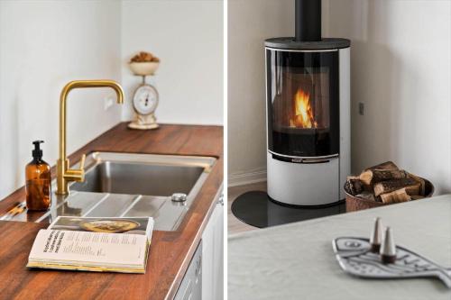 a kitchen with a stove and a sink with a fireplace at JB244-Logstor-Aggersborgvej-51 in Løgstør