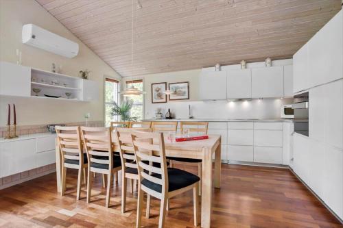 a kitchen with a wooden table and chairs at JB930-Fjerritslev-Revlingestien-85 in Torup Strand