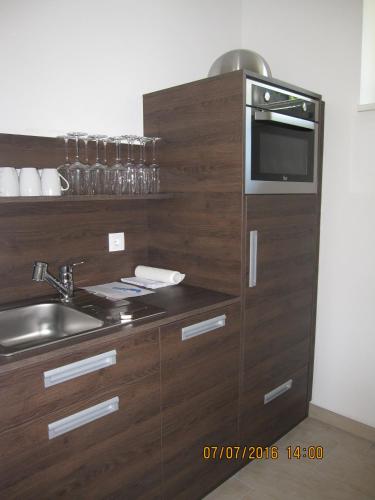 a kitchen with a sink and a microwave at Villa zur Schmied'n in Ehrenhausen