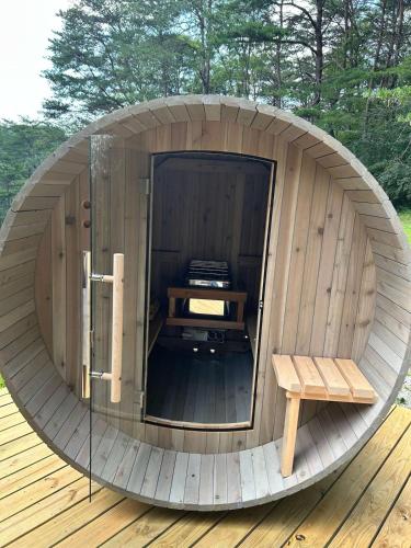 a circular wooden sauna with a bench in the middle at 10-Acre Cabin, Sauna, Hot Tub, Game Rm, Stargazing Dome, EV, BBQ in Logan