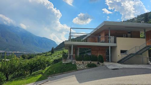 a house on a hill with mountains in the background at Agritur Gasadòr in Trento