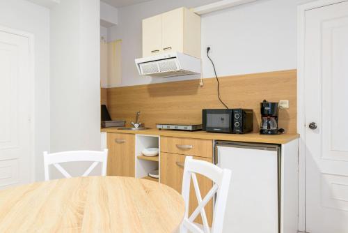 a small kitchen with a table and a microwave at Hotel Alda Ribeira in Ribeira