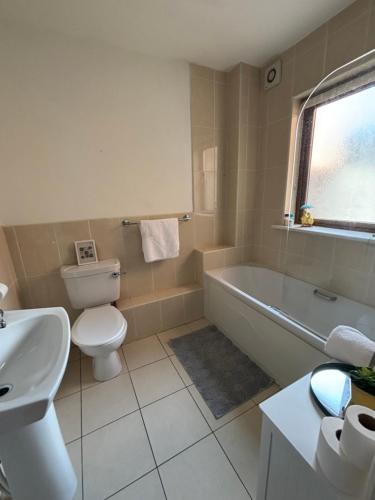 a bathroom with a toilet and a tub and a sink at Killaloe Lakeside Holiday Home 2Bedroom in Killaloe