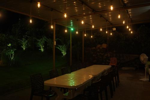 a table and chairs under a tent with lights at Vrindaa- The Bliss Retreat in Karjat