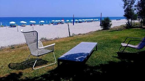 two chairs and a bench in front of the beach at Nina's house 4 a 300 mt dal mare in Santa Caterina Dello Ionio Marina