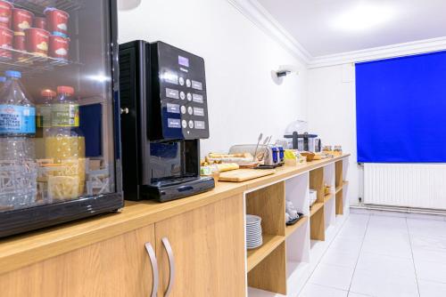 a kitchen with a microwave and a counter with food at Hotel Alda Ribeira in Ribeira