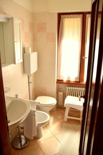 a bathroom with a white toilet and a sink at Albergo Casa Este in Brenzone sul Garda