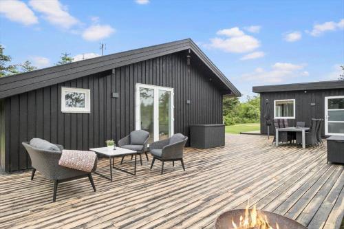a deck with chairs and a table and a building at JB318-Fjerritslev-Fiskerstien-10 in Torup Strand