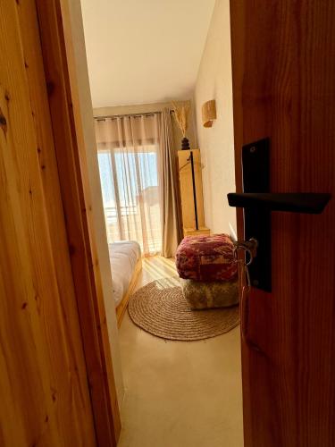 a room with a door open to a bedroom at SURFHALLA Morocco in Imsouane