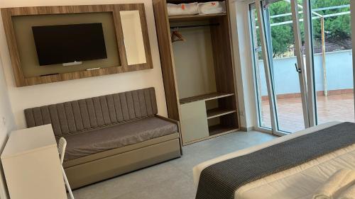 a living room with a couch and a tv on the wall at FAZIO ROOMS Roma in Rome