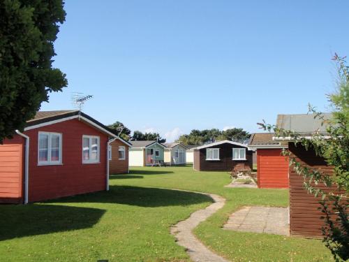 eine Reihe farbenfroher Häuser im Hof in der Unterkunft Chalets & Lodges at Atlantic Bays Holiday Park in Padstow