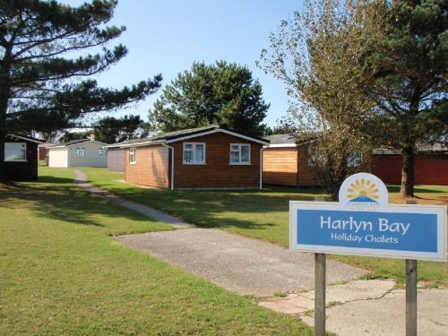 ein Schild vor einem Hof mit Häusern in der Unterkunft Chalets & Lodges at Atlantic Bays Holiday Park in Padstow