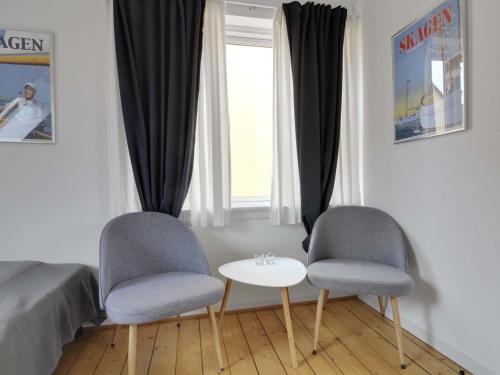 Un dormitorio con dos sillas y una mesa y una cama. en Apartment Zlatka - 250m from the sea by Interhome, en Skagen