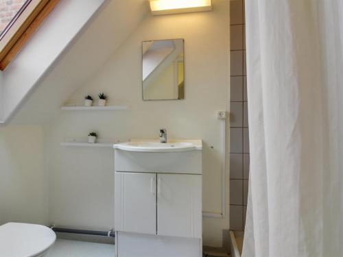 Un baño blanco con lavabo y espejo. en Apartment Siggut - 250m from the sea by Interhome, en Skagen