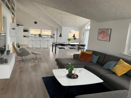 a living room with a couch and a table at Holiday Home Antina - 400m from the sea by Interhome in Hjørring