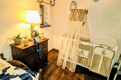 a crib in a room with a bed and a lamp at Nature rezidence private wellness in Zahorčice