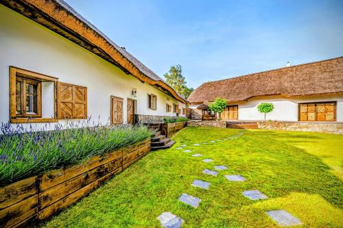 a house with a grass yard next to a building at Nature rezidence private wellness in Zahorčice