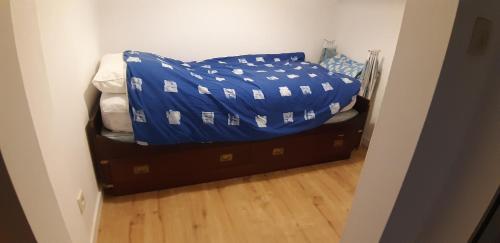 una cama con una cubierta azul encima en Miss Cato, en Ostende