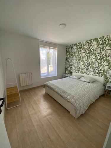 a bedroom with a large bed with a leafy wall at Appartement en Duplex en centre d'Isbergues in Isbergues