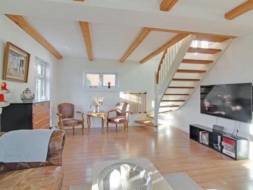 a living room with a tv and a staircase at Holiday Home Iara - 6km from the sea by Interhome in Bindslev