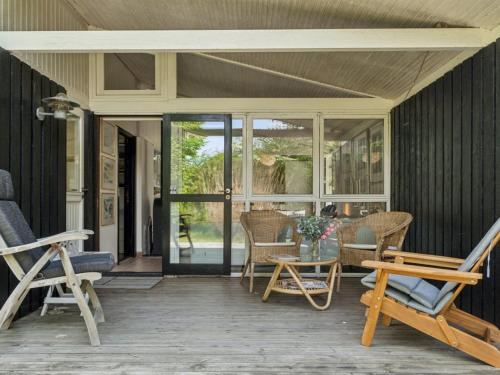 a screened in porch with chairs and a table at Holiday Home Ilsabet - 750m from the sea by Interhome in Gilleleje