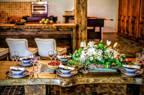 a table with a centerpiece of flowers and wine glasses at Nature rezidence private wellness in Zahorčice