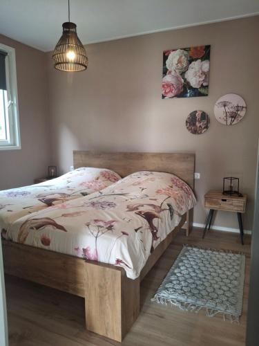 a bedroom with a bed with a wooden frame at B&B weidse blik Ingelum in Engelum