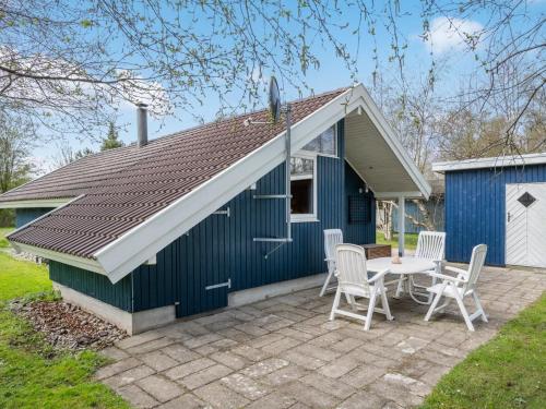 a blue and white shed with a table and chairs at Holiday Home Norna - 300m from the sea by Interhome in Store Fuglede