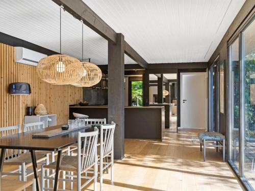 a kitchen and dining room with a table and chairs at Holiday Home Hævnir - 1km from the sea by Interhome in Vejby