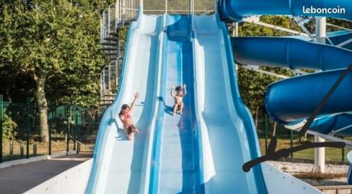 due persone su uno scivolo blu in un parco giochi di 531 Mobi-Chalet 3 chambres 2 sd Bassin d'Arcachon a La Teste-de-Buch