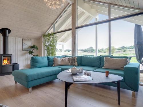 a living room with a blue couch and a table at Holiday Home Vara - 800m from the sea by Interhome in Vejby