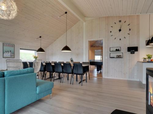 a dining room and living room with a clock on the wall at Holiday Home Vara - 800m from the sea by Interhome in Vejby