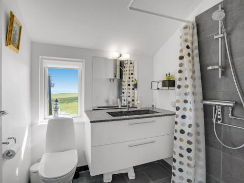a bathroom with a sink and a toilet and a window at Holiday Home Trajko - 100m from the sea by Interhome in Hou
