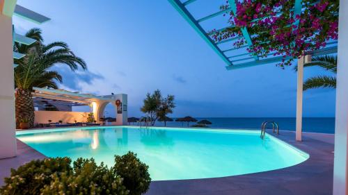 a swimming pool with the ocean in the background at Sigalas Beach Hotel in Kamari