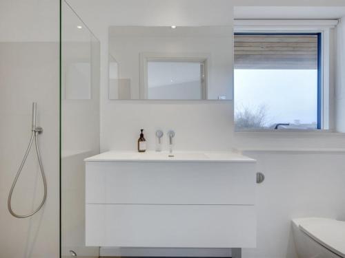 a white bathroom with a sink and a mirror at Holiday Home Ebke - 70m from the sea by Interhome in Gilleleje