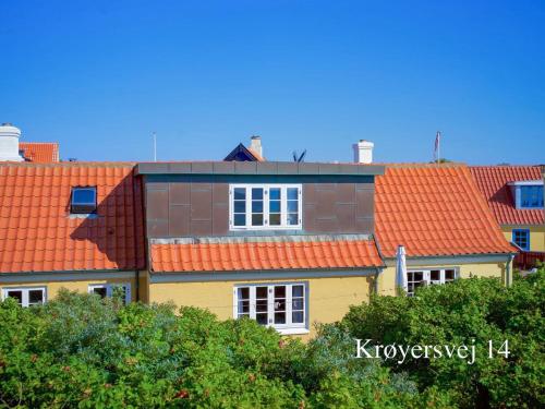 a yellow house with orange roofs at Holiday Home Ingwald - 50m from the sea by Interhome in Skagen