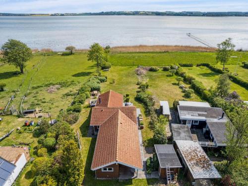 an aerial view of a house on a field with the water at Holiday Home Brunman - 10m to the fjord by Interhome in Grevinge