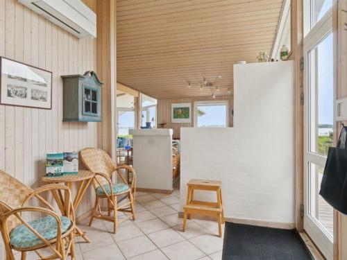 a room with chairs and a white refrigerator at Holiday Home Brunman - 10m to the fjord by Interhome in Grevinge