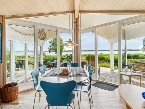a dining room with a table and chairs at Holiday Home Brunman - 10m to the fjord by Interhome in Grevinge